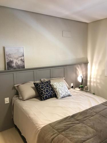 a bedroom with a large bed with pillows on it at Apartamento Vêneto in Canela