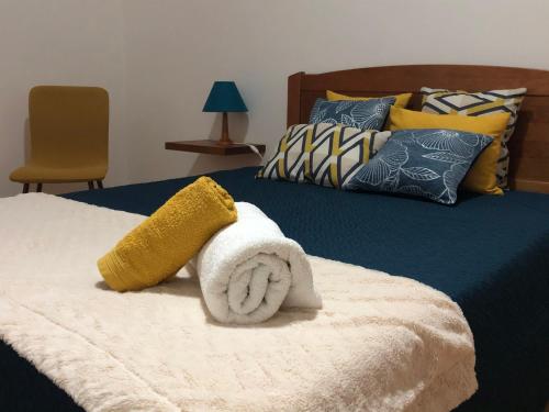 a bed with a towel on top of it at Central House in Ribeira Grande