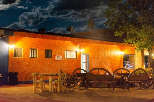a group of tables and chairs in front of a building at Villa Mexicana Creel Mountain Lodge in Creel