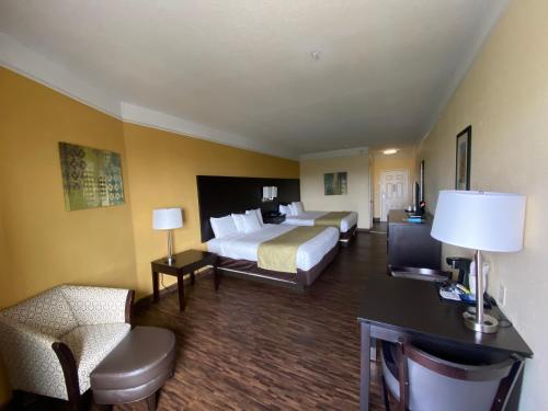 a hotel room with two beds and a desk at Galveston Beach Hotel in Galveston
