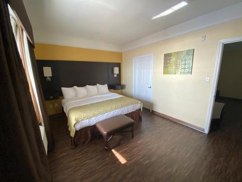 a hotel room with a bed and a chair at Galveston Beach Hotel in Galveston