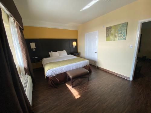 a hotel room with a bed and a chair at Galveston Beach Hotel in Galveston