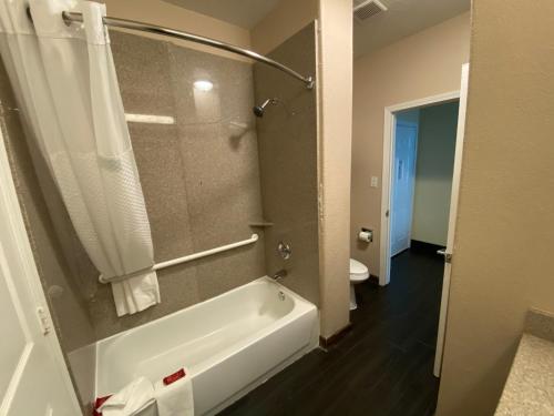 a bathroom with a white tub and a toilet at Galveston Beach Hotel in Galveston