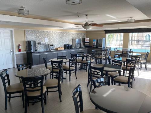 a restaurant with tables and chairs and a kitchen at Galveston Beach Hotel in Galveston