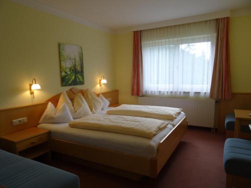 um quarto de hotel com duas camas e uma janela em Hotel Sportpension Reiter em Planneralm