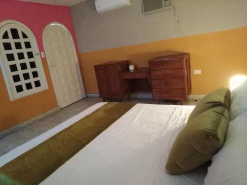 a bedroom with a large bed and a dresser at Casa Lool Beh in Mérida