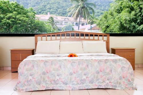 Un dormitorio con una cama grande con flores. en Coral Vista Del Mar en Ixtapa