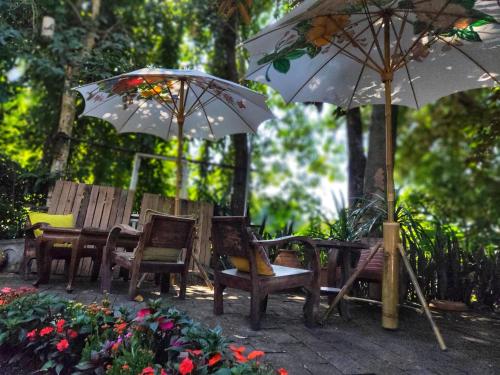 a group of chairs and umbrellas in a garden at Sukjai Guesthouse in Chiang Mai