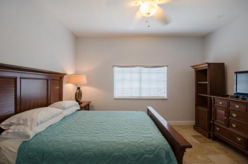 a bedroom with a bed and a dresser and a television at Vistalmar Beach Resort in Deerfield Beach