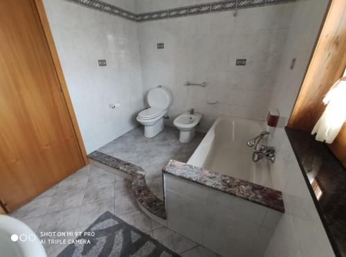 uma casa de banho com uma banheira e um WC. em I capricci dell'Etna 2 di Puglisi em Mascalucia