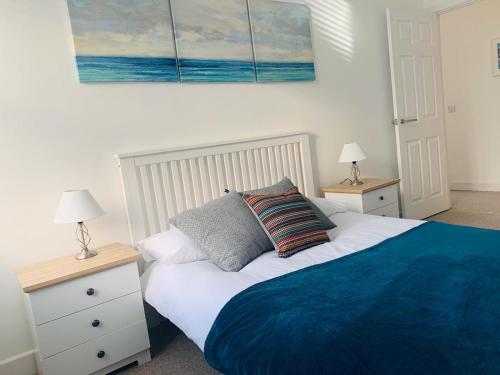 a bedroom with a bed with two night stands and two lamps at Ferry House in Pembroke Dock