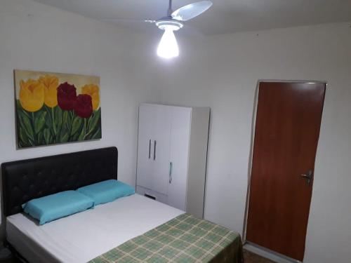 a bedroom with a bed and a painting of flowers at Hostel Gerais in Belo Horizonte