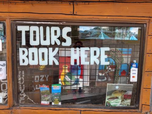 a store window with a tour book sign in it at Hostel Paco House in Monteverde Costa Rica
