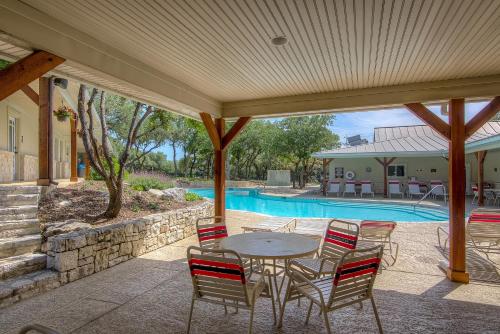 un patio con mesa, sillas y piscina en Sun Retreats San Antonio West, en San Antonio