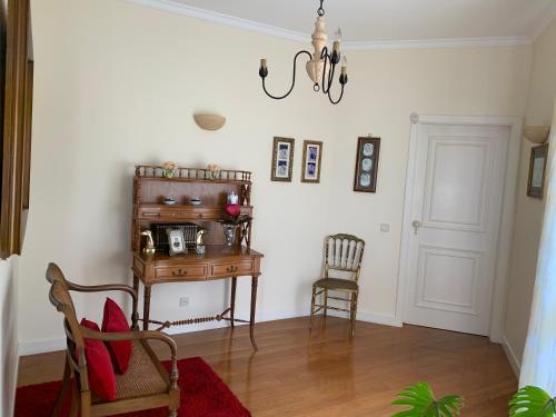a room with a desk and a chair and a chandelier at Vila Tagus Garajau in Caniço