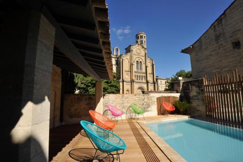 a group of chairs sitting next to a swimming pool at Boutique Hôtel Entraigues in Uzès