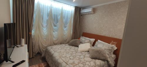 - une chambre avec un lit doté d'oreillers et d'une fenêtre dans l'établissement Casa LUX, à Bucarest