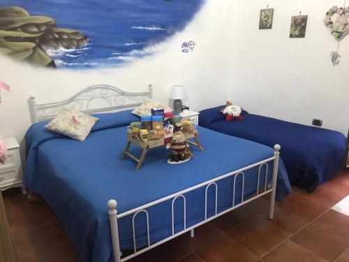 a bedroom with two beds with blue sheets and a table at B&B Ruffo Nel cuore di Napoli in Naples