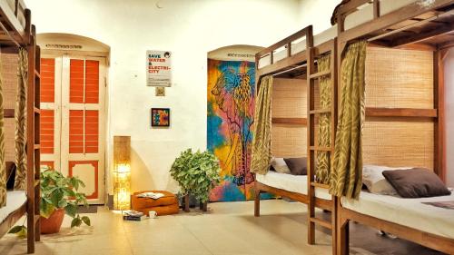 a room with three bunk beds and a mural at International Travellers' Hostel by ITH Stays in Varanasi