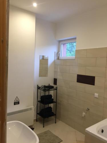 a bathroom with a tub and a sink and a window at Budapest Airport , accommodation in Vecsés in Vecsés