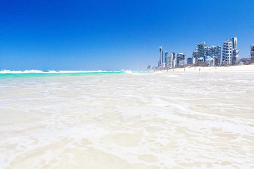 uitzicht op een strand met een stad op de achtergrond bij The Waterford on Main Beach in Gold Coast