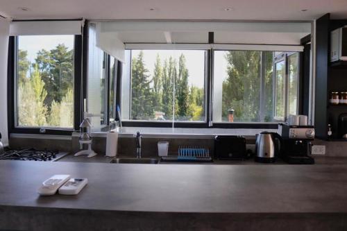 a kitchen with two large windows and a counter top at Limay Bed&Breakfast in Neuquén