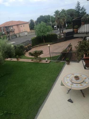 a garden with a table and a green lawn at I capricci dell'Etna 1 di Puglisi in Mascalucia