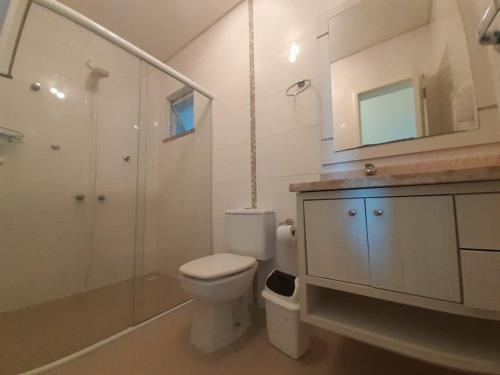 y baño con aseo, lavabo y ducha. en Apartamento Terra Nova Mariscal, en Bombinhas