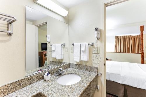 a bathroom with a sink and a large mirror at Americas Best Value Inn and Suites El Centro in El Centro