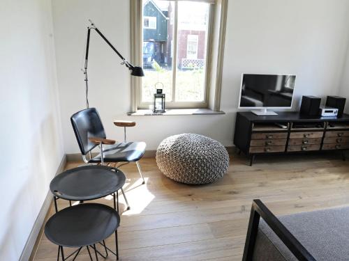 sala de estar con 2 sillas, mesa y TV en Fisherman s house near the Lauwersmeer, en Zoutkamp