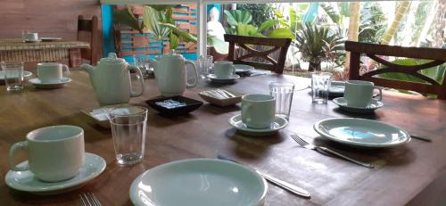 a wooden table with plates and dishes on it at Pousada Gaucha Caiobá in Matinhos