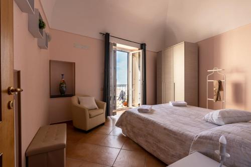 a bedroom with a bed and a chair and a window at Casa Vacanza da Giggino in Ravello