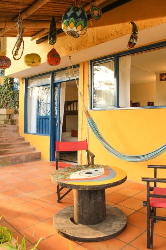 a patio with a table and a swing at Casa Encuentro Ecolodge, Outdoor Gym and Yoga in Guatapé