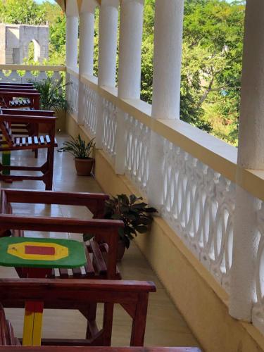 a balcony with wooden chairs and a white railing at Solet's Paradise Negril in Negril
