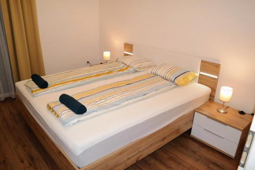 a large white bed with two pillows on it at Riverside Apartman with Free Parking in Győr