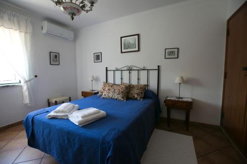 a bedroom with a blue bed with towels on it at Tapada da Beirã in Marvão