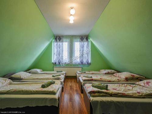 a room with four beds in a room with a window at Dom Wczasowy " U Józefa " in Zakopane