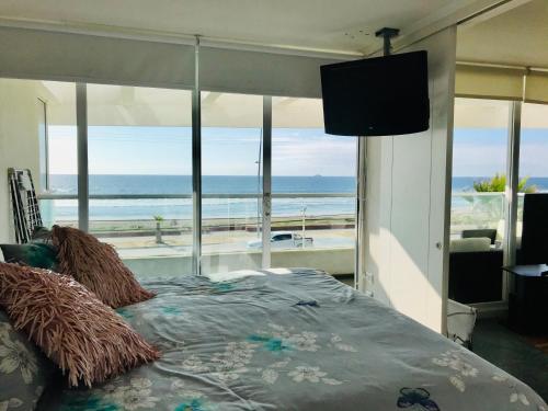 a bedroom with a bed with a view of the ocean at Descanso frente al mar Neohaus La Serena in La Serena