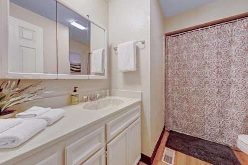 La salle de bains blanche est pourvue d'un lavabo et d'une douche. dans l'établissement Home in the Silicon Forest, à Beaverton