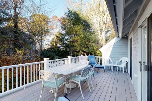 a patio with a table and chairs on a deck at Summersea in Mashpee
