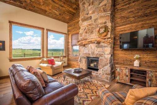 a living room with a couch and a stone fireplace at Zion Mountain Ranch in Mount Carmel Junction