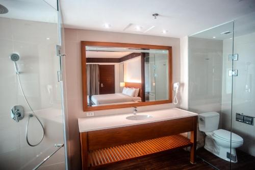 a bathroom with a sink and a toilet and a mirror at Mandarin White Sand Boracay in Boracay