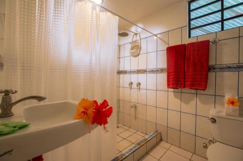 a bathroom with a sink and a toilet and red towels at Casa Margarita in Puerto Viejo