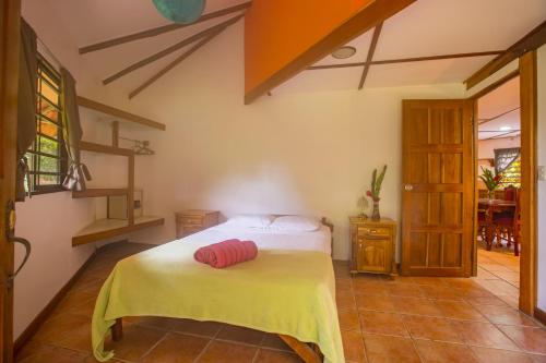 a bedroom with a bed with a yellow blanket on it at Casa Margarita in Puerto Viejo