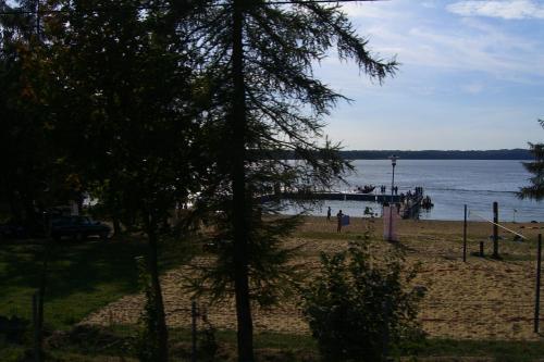 a beach with a pier and people on the water at Dom Wczasowy Pięciu Pomostów in Czaplinek