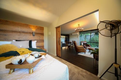 a bedroom with a bed and a living room at L'amour Nest in Napier