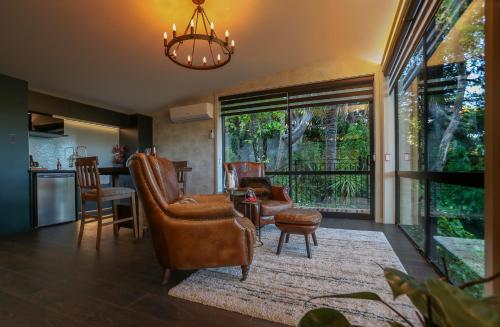 a living room with chairs and a table at L'amour Nest in Napier