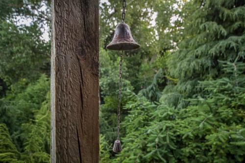 a bell hanging from the side of a tree at L'amour Nest in Napier
