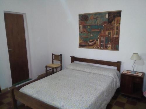 um quarto com uma cama e um quadro na parede em El Cortijo de la villa em Villa Independencia