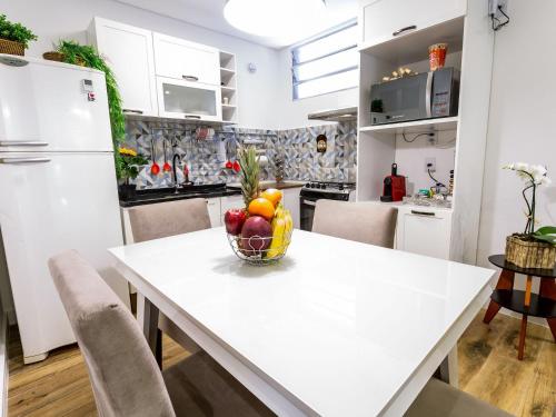 a kitchen with a white table with a bowl of fruit at Apartamento com 2 Quartos em Alto de Pinheiros in Sao Paulo